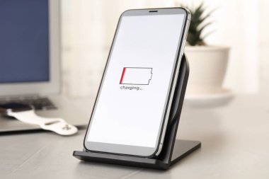 Mobile phone charging with wireless device on light grey stone t
