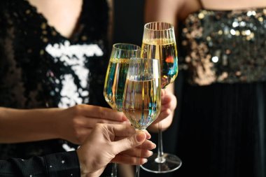 Women clinking glasses of champagne at party, closeup