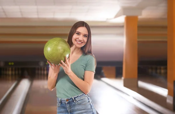 Молодая женщина с мячом в боулинг-клубе — стоковое фото
