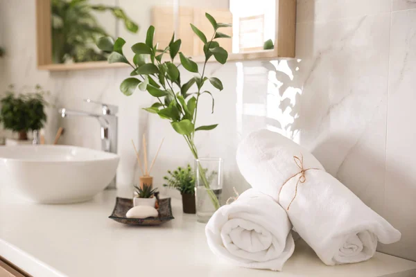 Towels and green plants on white countertop in bathroom. Interio — Stock Photo, Image