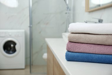 Stack of fresh towels in bathroom, space for text. Laundry day