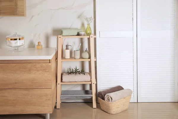 Shelving unit with toiletries in stylish bathroom interior — Stock Photo, Image