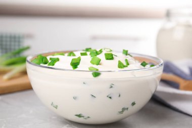 Gri mermer masada soğanlı taze ekşi krema, yakın plan.