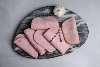 Tasty ham served on light grey table, top view