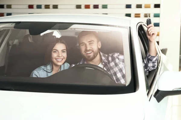 Casal Feliz Com Chave Carro Sentado Automóvel Moderno Concessionária — Fotografia de Stock