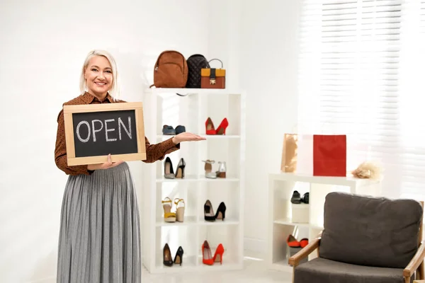 Propietaria de una empresa femenina que sostiene el cartel OPEN en boutique. Espacio para t — Foto de Stock