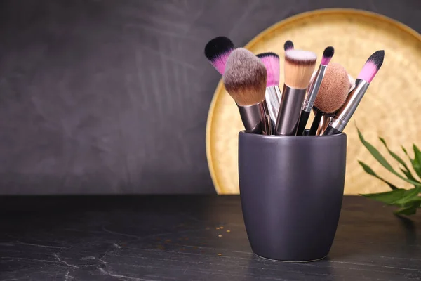 Set de pinceles de maquillaje profesionales en soporte sobre mesa negra. Spa — Foto de Stock