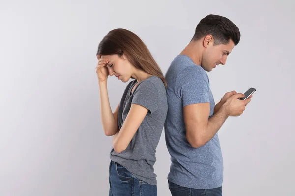 Hombre Con Smartphone Ignorando Novia Fondo Claro Problemas Relación — Foto de Stock