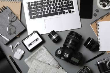 Flat lay composition with equipment for journalist on grey table