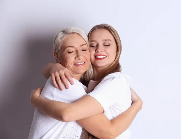 Mother and her adult daughter on white background — Stock Photo, Image