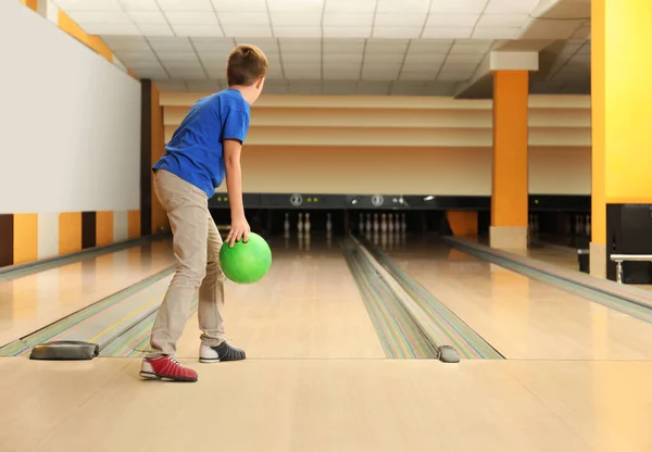 Preteen boy throwing ball at bowling club. Space for text — ストック写真