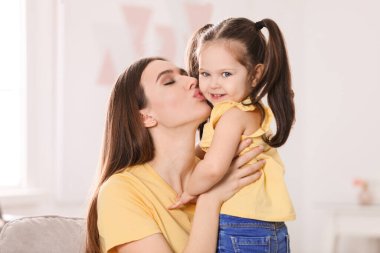 Young mother with little daughter at home