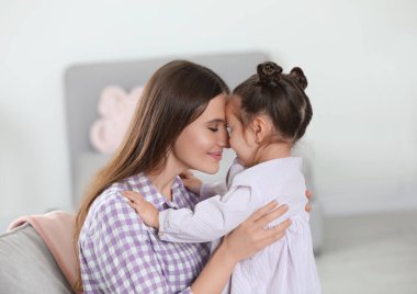 Young mother with little daughter at home