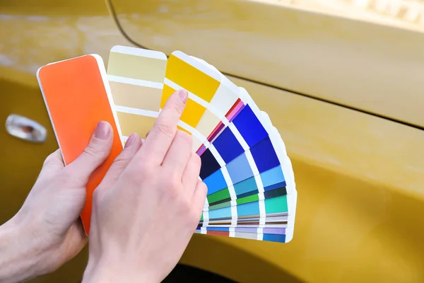 Donna con tavolozza campioni scegliendo il colore per la pittura auto, clos — Foto Stock