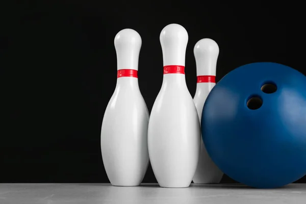 Blue bowling ball and pins on light grey marble table — ストック写真