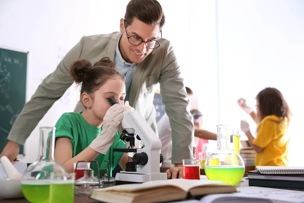 Teacher with pupil at chemistry lesson in classroom — Stok fotoğraf