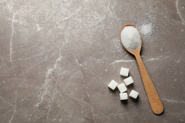 Cuchara de azúcar blanco en la mesa de mármol, puesta plana. Espacio para texto — Foto de Stock