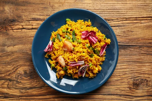 Delizioso pilaf di riso con pollo e verdure sul tavolo di legno — Foto Stock