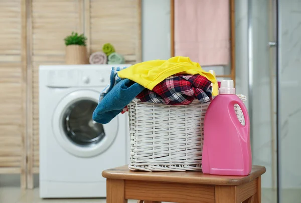 Wicker basket with laundry and detergent in bathroom — Stockfoto