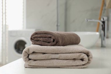 Banyo tezgahında bir yığın temiz havlu var.
