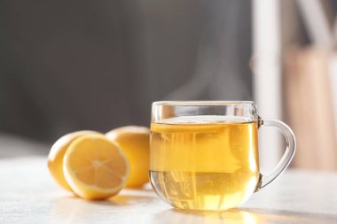 Beyaz masadaki limonlu bir bardak çay bulanık arka planda, mesaj için yer var. Kış içeceği