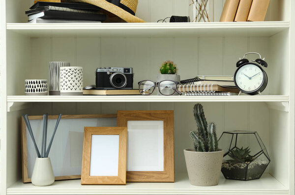 White shelving unit with photo frames and different decorative elements