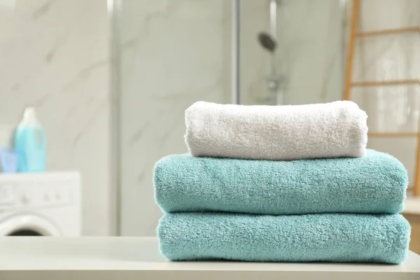 Çamaşır odasında masada temiz havlu yığını. Metin için yer