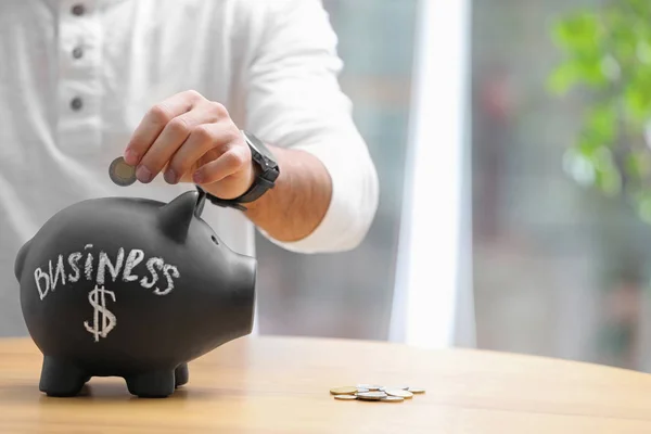 Man Putting Money Piggy Bank Word Business Table Closeup Space — Stock Photo, Image