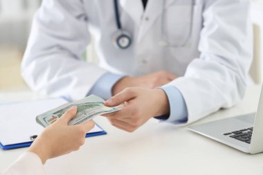 Hasta klinikteki doktora rüşvet veriyor, yakın plan. Yozlaşmış tıp