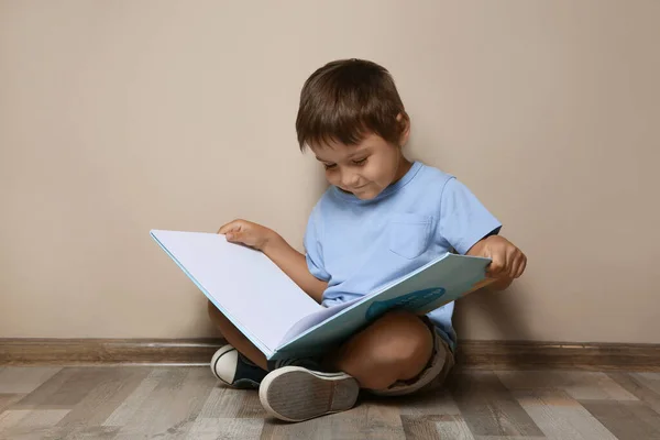 Netter Kleiner Junge Liest Buch Auf Dem Boden Neben Beiger — Stockfoto