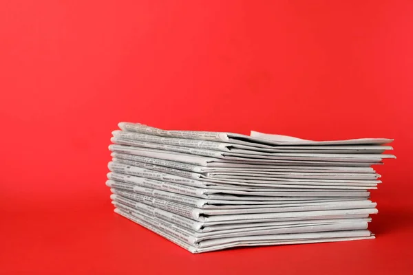 Στοίβα εφημερίδων σε κόκκινο φόντο. Έργο δημοσιογράφου — Φωτογραφία Αρχείου