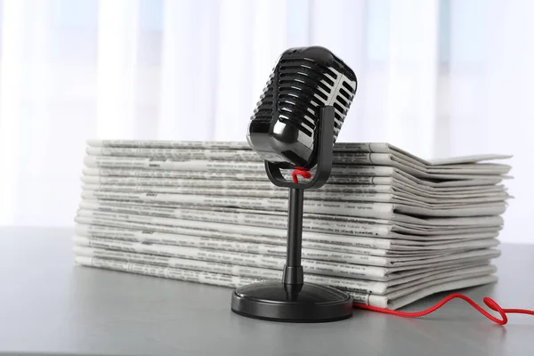 Kranten en vintage microfoon op grijze tafel. Journalist 's vrouw — Stockfoto