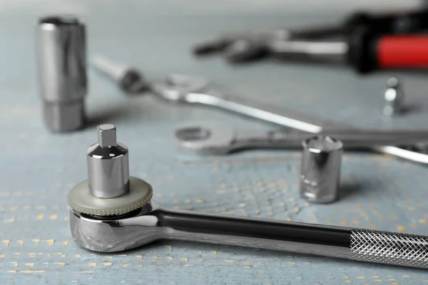 Auto mechanic\'s tool on grey wooden table, closeup