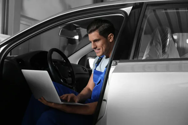 Mécanicien avec ordinateur portable faisant le diagnostic de voiture à la réparation automobile s — Photo