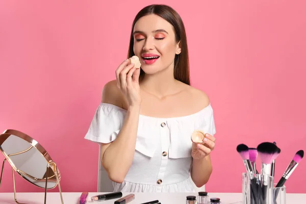 Beauty blogger použití balzám na rty na růžovém pozadí — Stock fotografie