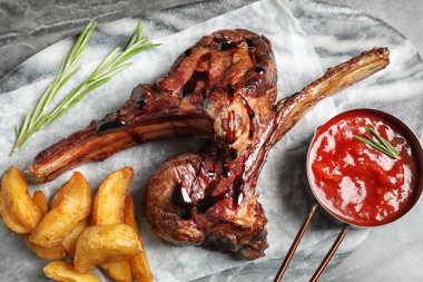 Gri masada servis edilen nefis ızgara pirzola.