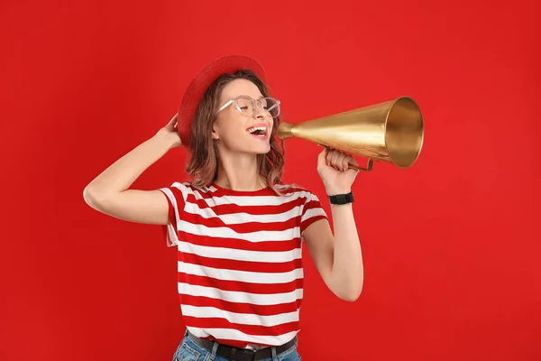 Jovem mulher com megafone no fundo vermelho — Fotografia de Stock