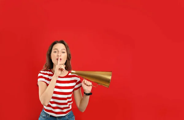 Jovem mulher com megafone no fundo vermelho — Fotografia de Stock