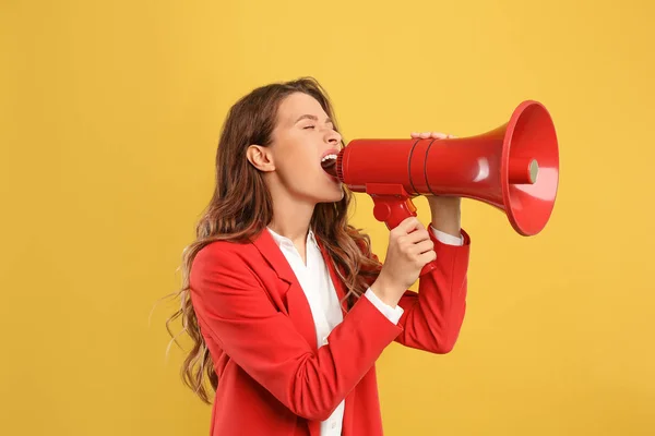 Jovem mulher com megafone no fundo amarelo — Fotografia de Stock