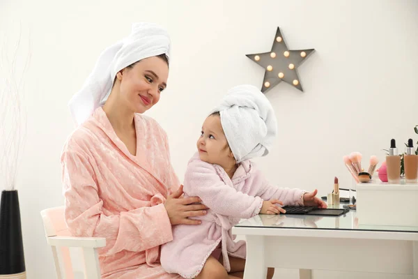 Ung mor och liten dotter vid omklädningsbordet — Stockfoto