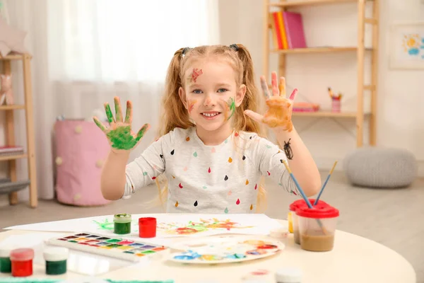 Jolie petite peinture d'enfant avec des paumes à la table — Photo