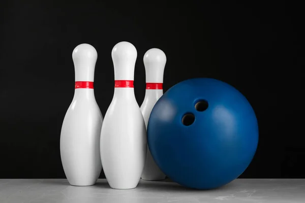 Blue bowling ball and pins on light grey marble table — ストック写真