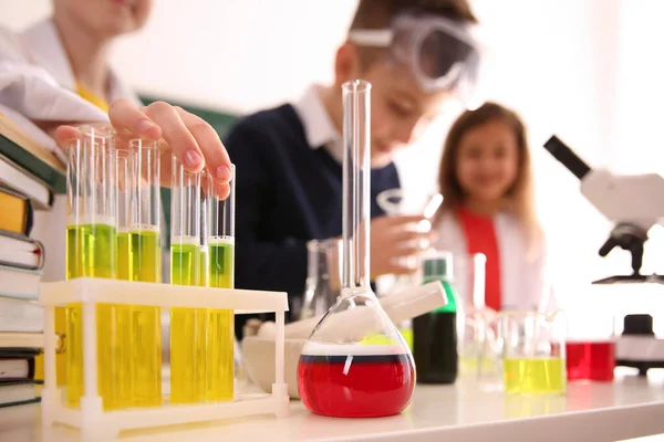 Smart pupils making experiment in chemistry class, focus on flas — 스톡 사진