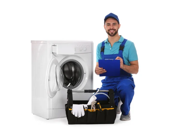 Çamaşır makinesinin yanında pano ve alet çantası olan bir tamirci. — Stok fotoğraf