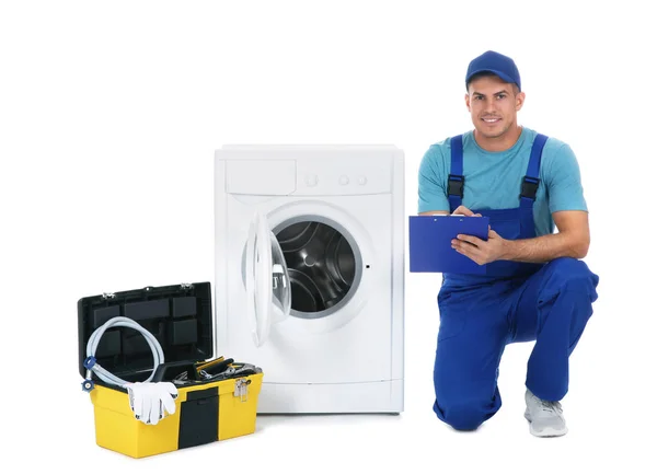 Çamaşır makinesinin yanında pano ve alet çantası olan bir tamirci. — Stok fotoğraf