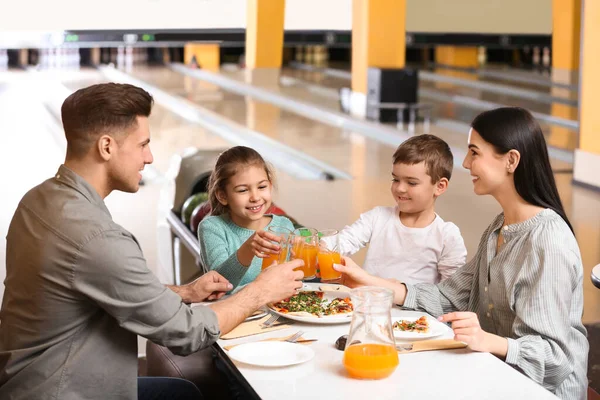 Família feliz com pizza e bebidas no clube de bowling — Fotografia de Stock