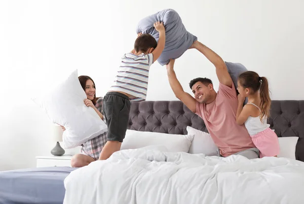 Happy family having pillow fight in bedroom — 스톡 사진