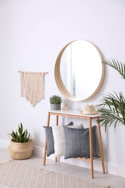 Round mirror and wooden table at home. Idea for interior design