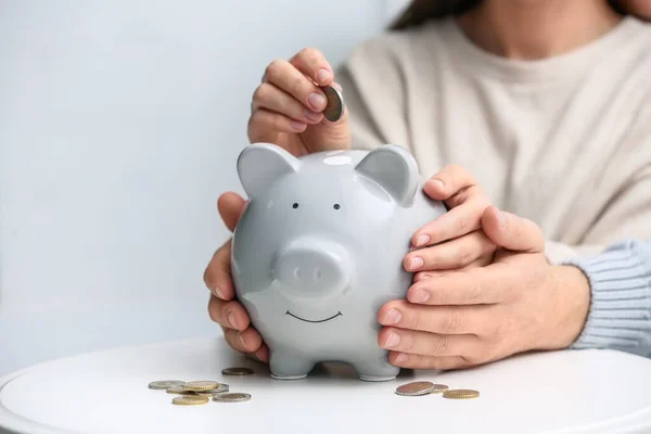 Couple with piggy bank at white table, closeup — Stock Photo, Image