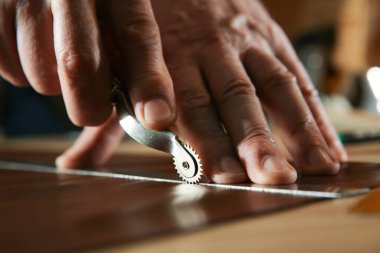 Deriyi atölyede paten ile işaretleyen adam, yakın plan
